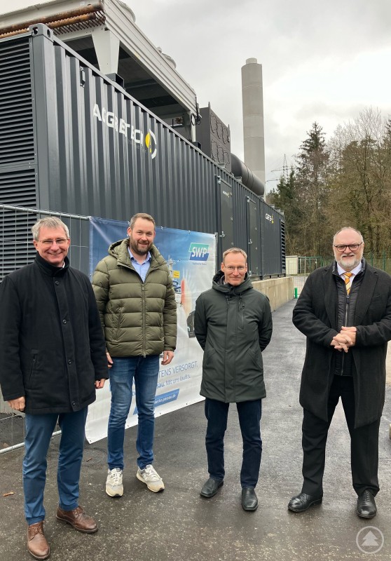 Vor Ort besichtigen Oberbürgermeister Jürgen Dupper (rechts), Stadtwerke-Geschäftsführer Prof. Dr. Stephan Prechtl (links) sowie Christian Bauer, Technischer Leiter Netze und Erzeugung bei den Stadtwerken (2. von rechts) und Stadtwerke-Projektleiter Anton Gerlesberger (2. von links) das neue Notstromaggregat in Grubweg. Bildquelle SWP - Notstromaggregat Grubweg_17.12.2024.jpg