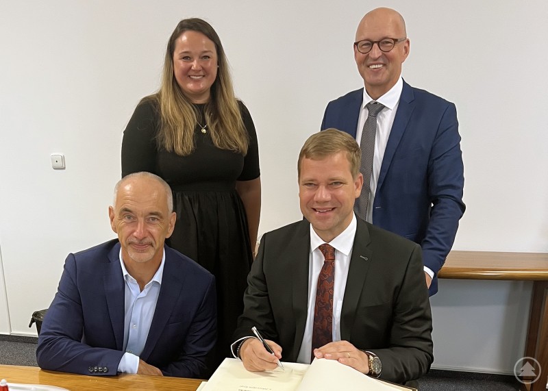 Erklärten ihre Bereitschaft zur Zusammenarbeit: Vorne von links Südböhmens Kreishauptmann Dr. Martin Kuba und Bezirkstagspräsident Dr. Olaf Heinrich, dahinter die Leiterin der Abteilung Außenbeziehungen Kateřina Pospíšilová und Euregio-Geschäftsführer Kaspar Sammer. Vier Personen posieren in einem Konferenzraum. Zwei Männer sitzen vorne an einem Tisch, einer von ihnen unterschreibt ein Dokument. Dahinter stehen eine Frau und ein weiterer Mann, alle lächeln in die Kamera.