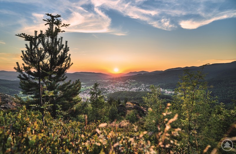 Stimmungsvolle Abendstimmung über Bodenmais im Bayerischen Wald. Sonnenuntergang über Bodenmais mit Blick auf die Ortschaft und umliegende Berge, im Vordergrund Natur und Bäume.