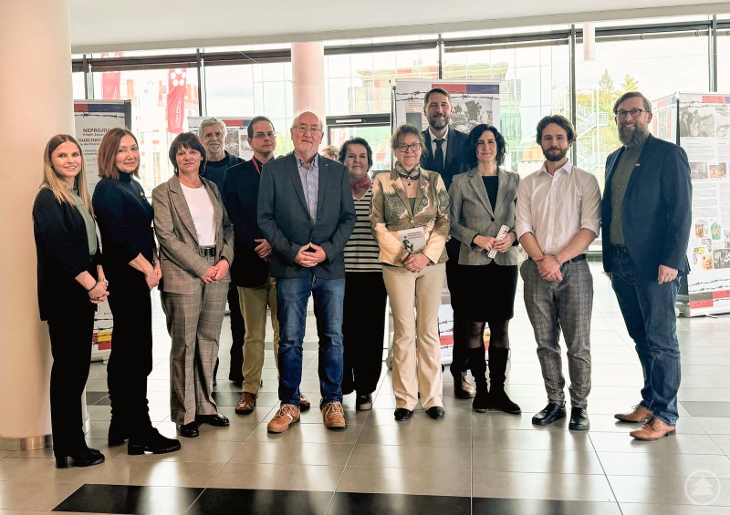 v.r. Christian Fiebig (Landratsamt), Daniel Musílek (Universität Budweis), Dr. Markéta Ederová (Universität Budweis), Prof. Ondřej Pešek (Universität Budweis), Zuzana Jonová (Kuratorin), Dr. Magdalena Malechová (Universität Budweis), Dr. Jürgen Eder (Universität Budweis), Dr. Miroslav Šepták (Universität Budweis), Ivan Falta (Kulturverein Über d Grenz), Romana Karmazínová (Kulturamt Stadt Třeboň), Selma Šedová Keck (Landratsamt), Julia Bauer (Landratsamt) Gruppenfoto mehrerer Vertreter aus Politik, Wissenschaft und Kultur bei der Eröffnung einer Ausstellung in einem modernen Gebäude.