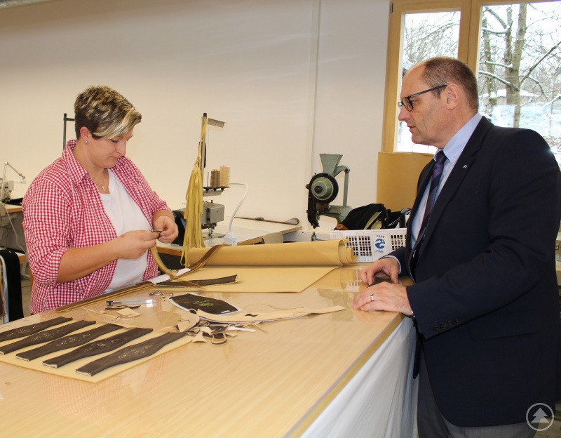 Thomas Breinfalk, Handelsreferent bei der IHK für Niederbayern in Passau ließ sich von Caro Graßl, erklären, wie die Lederhosen-Träger produziert werden.